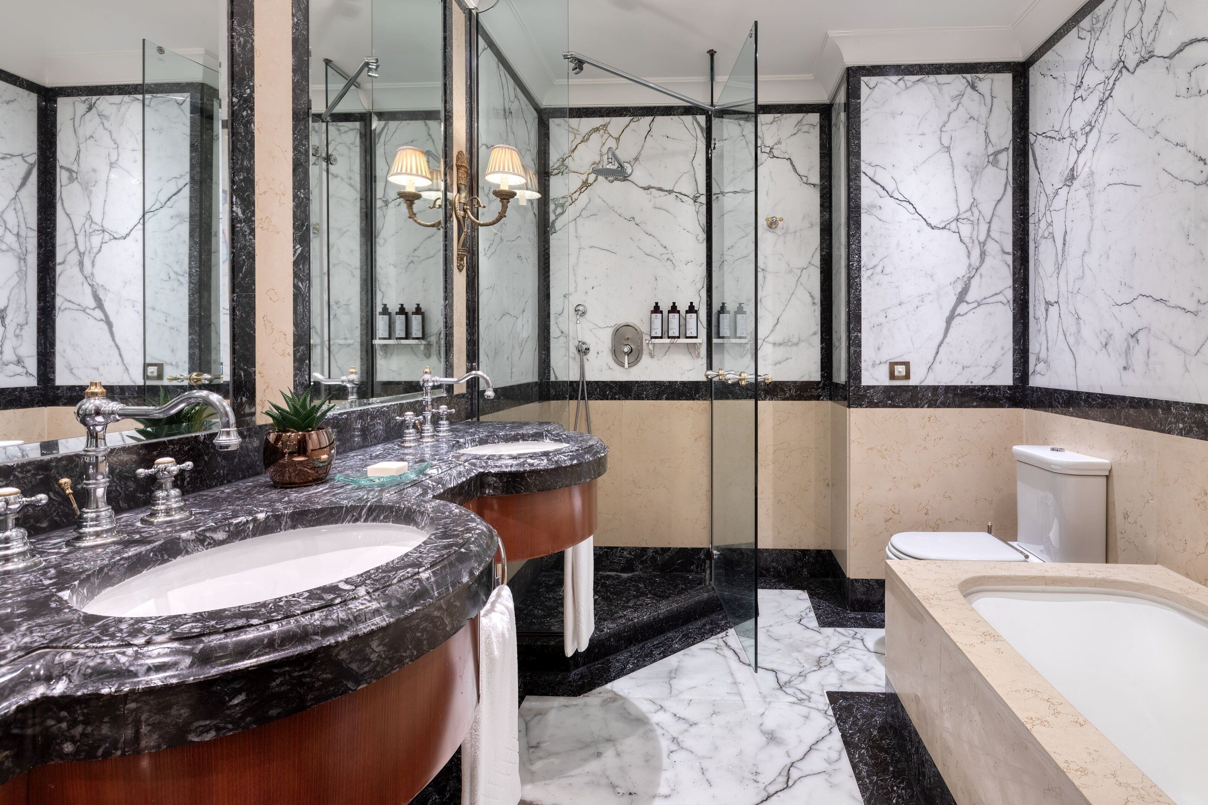 A modern bathroom with two sinks, a bathtub, and a shower.