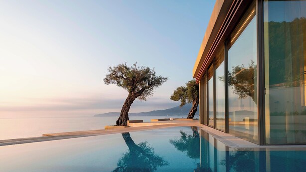 A modern infinity pool with a clear view of the sea and mountains in the background. - Domes Miramare, a Luxury Collection Resort, Corfu - Adults Only (Corfu)