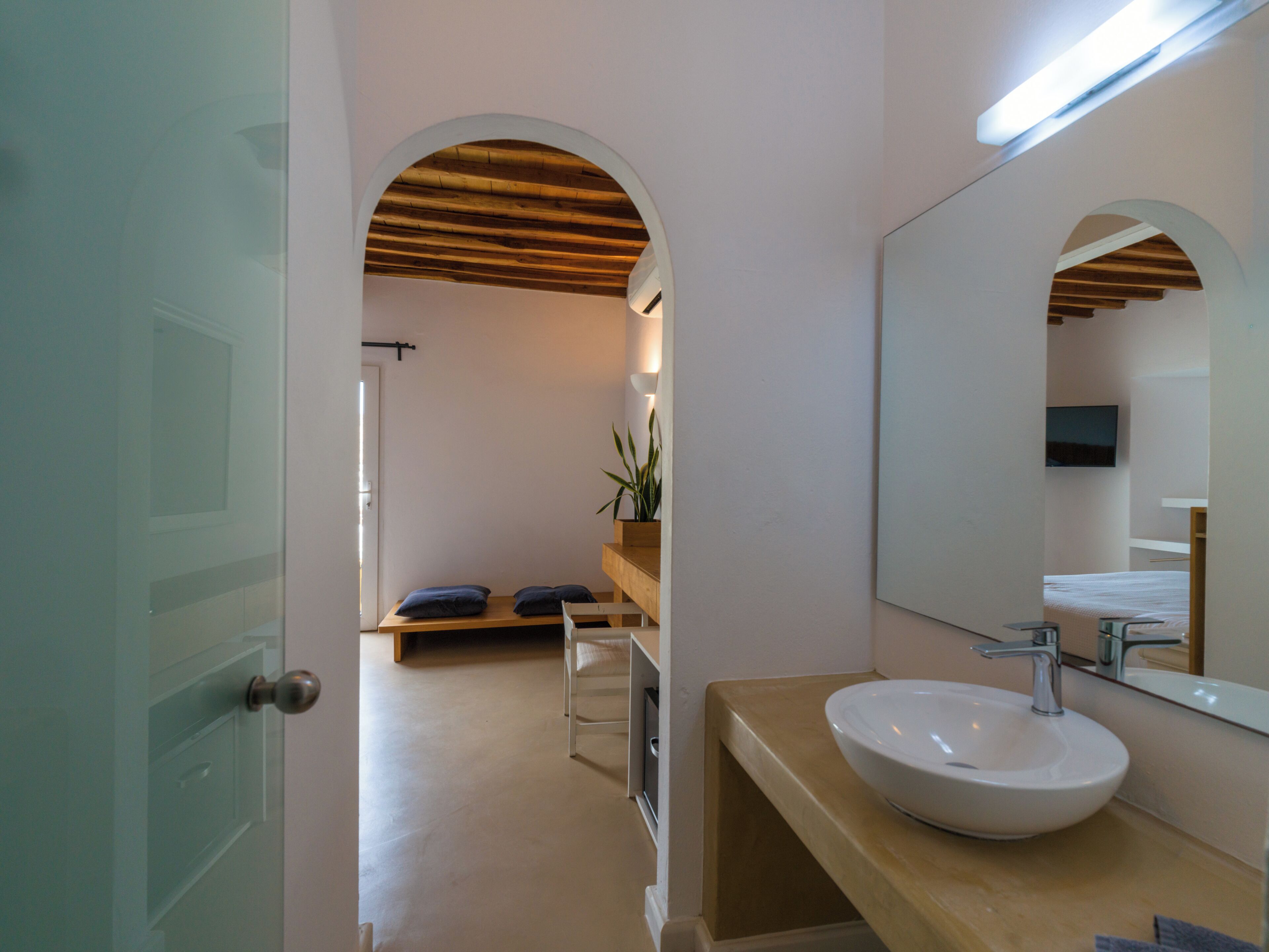 Een badkamer met een grote spiegel, een wastafel en een douche.
