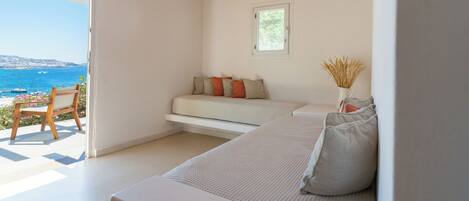 A room with a bed, a window, and a view of the sea.