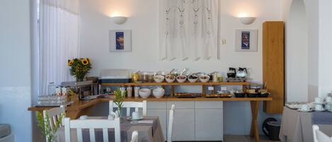 Un comedor con mesas, sillas y una barra libre de alimentos, además de un aire acondicionado instalado en la pared.