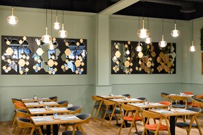 A modern interior with hexagonal wall art, wooden tables, and chairs. - Hotel Erzsébet City Center Budapest, a member of Radisson Individuals (Budapest)