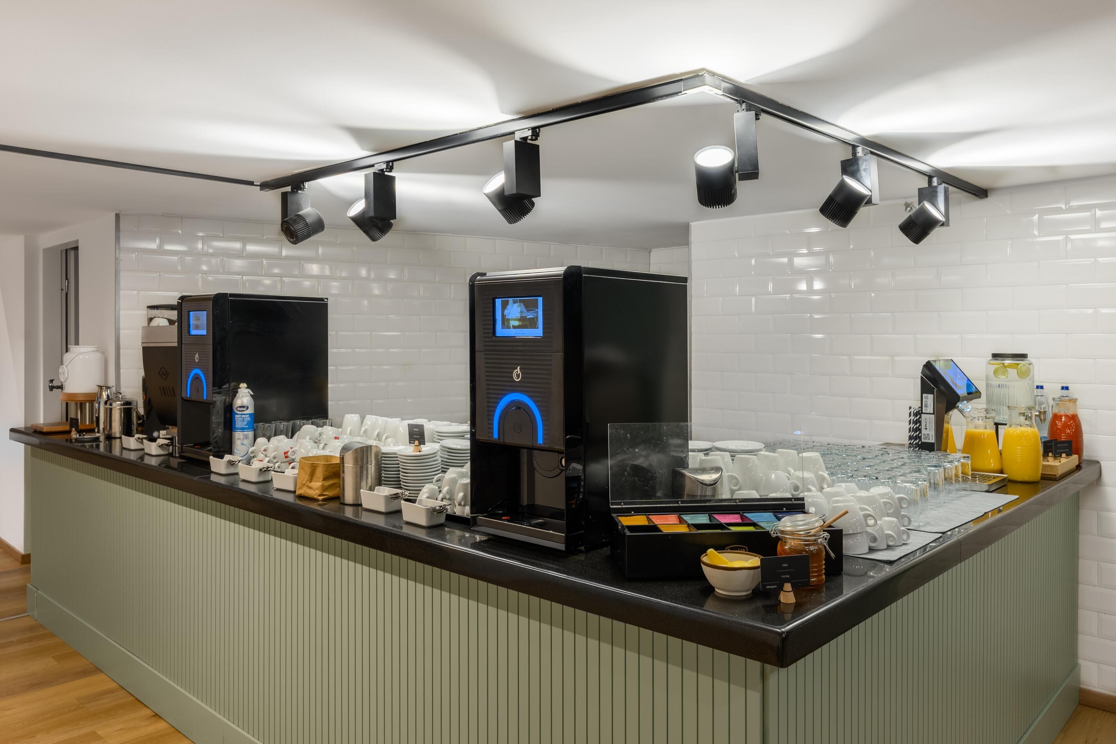 Eine Selbstbedienungs-Kaffeestation mit mehreren Kaffeemaschinen, verschiedenen Tassen und einer Auswahl an Getränken.