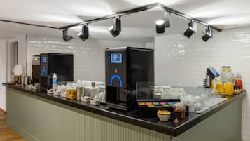 Eine Selbstbedienungs-Kaffeestation mit mehreren Kaffeemaschinen, verschiedenen Tassen und einer Auswahl an Getränken.