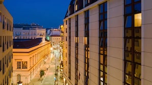 A hotel with a long facade, large windows, and a well-lit interior.