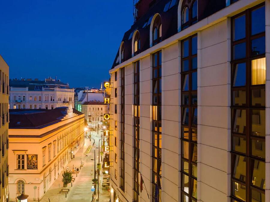 Un hotel con una fachada larga, ventanas amplias y un interior bien iluminado.