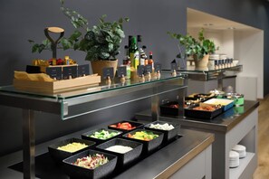 A buffet setup with various food items and condiments.