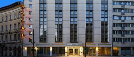 Un hotel de varios pisos con fachada moderna, amplias ventanas y un letrero que indica que es un miembro de Radisson Individuals.