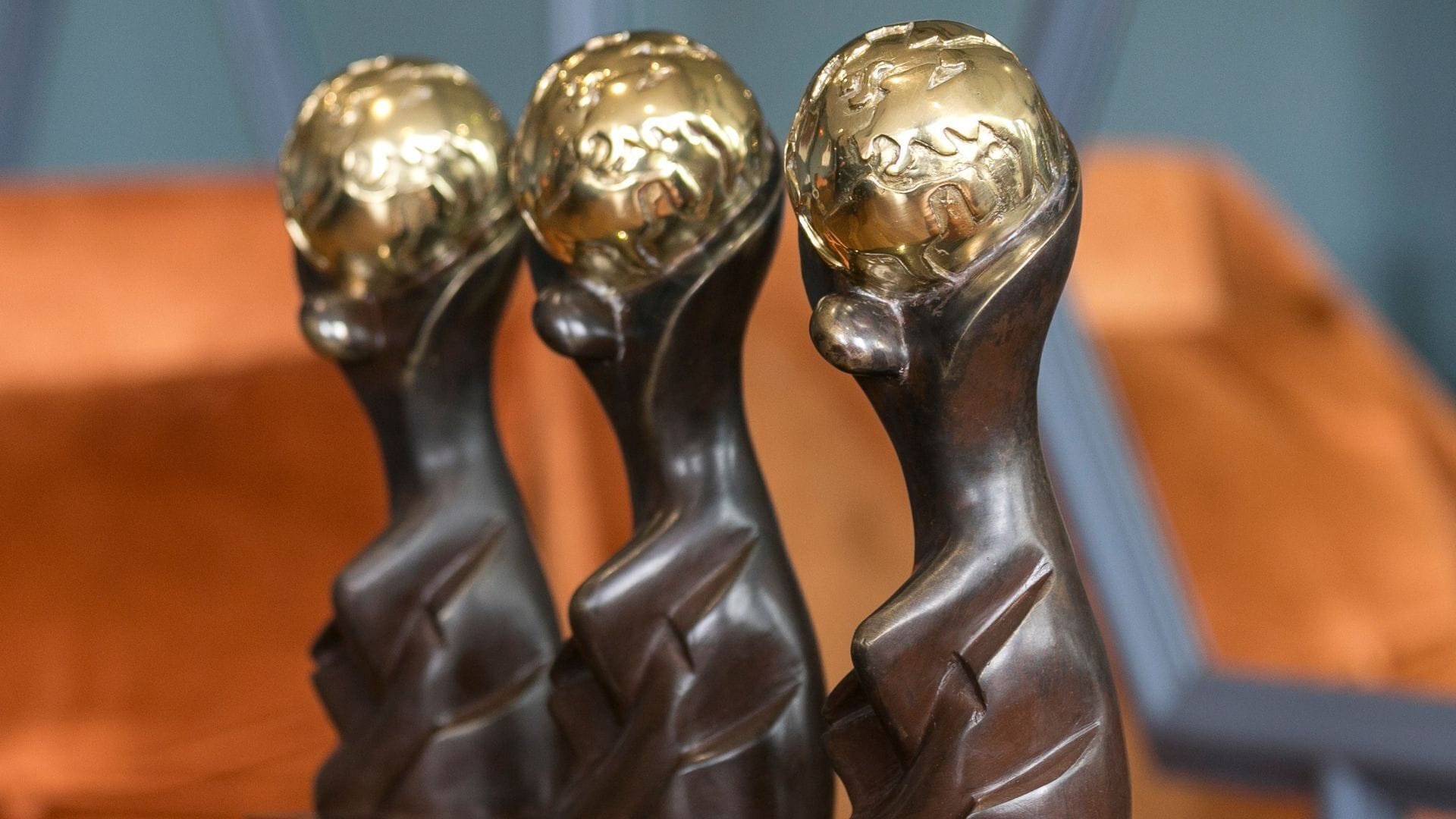 Three trophies with golden tops and dark bases.