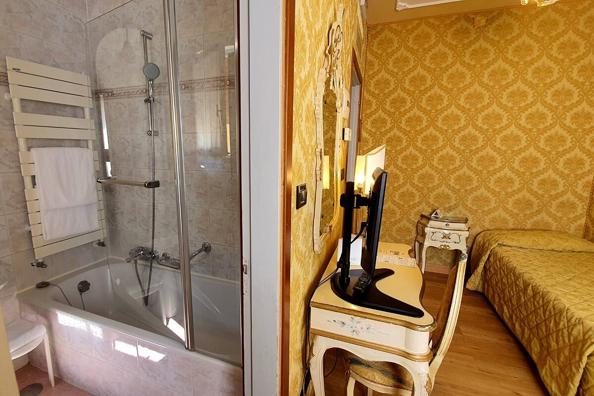 A bathroom with a glass-enclosed shower and a separate bathtub.