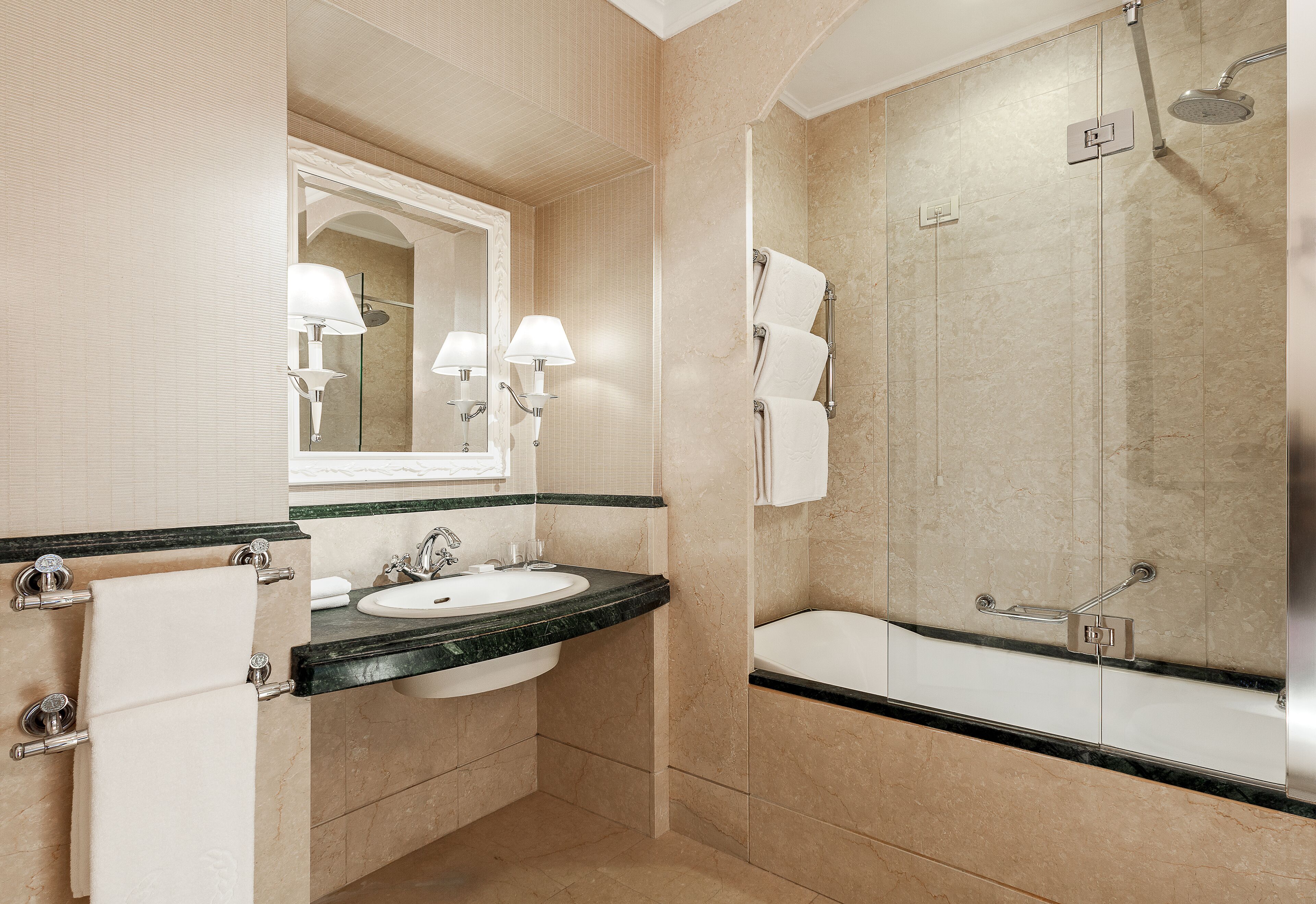 A modern bathroom with a sink, mirror, and a walk-in shower.