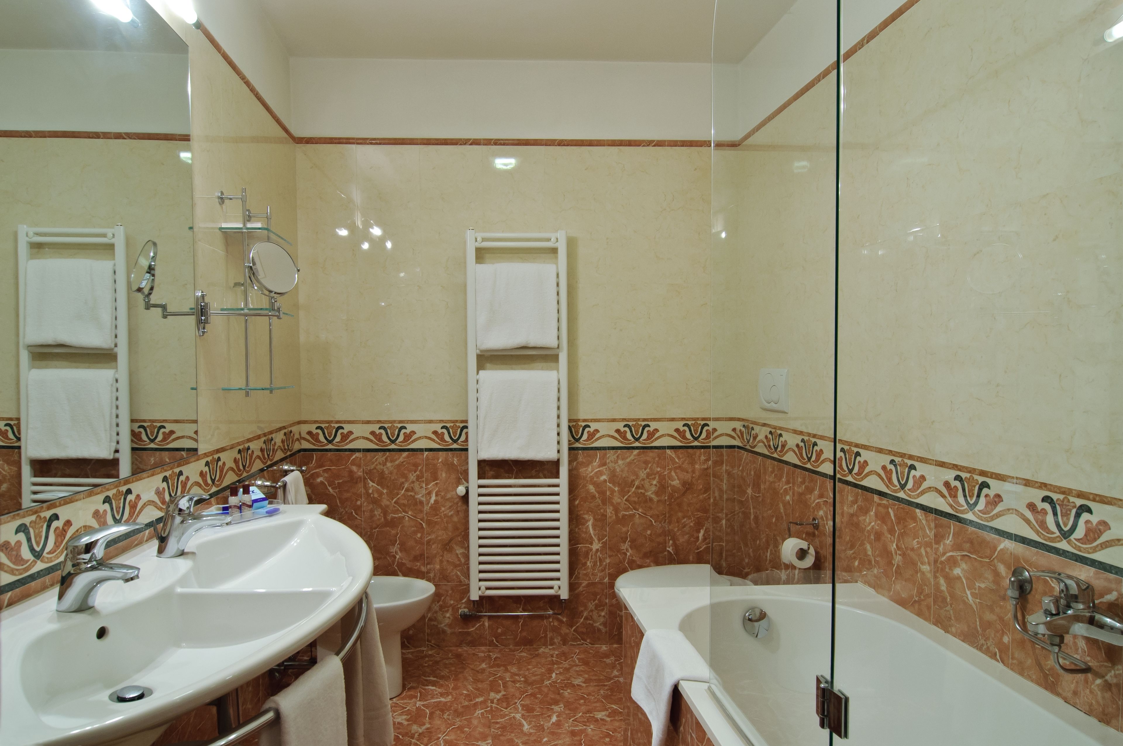 A bathroom with two sinks, a toilet, a bathtub, and a mirror.