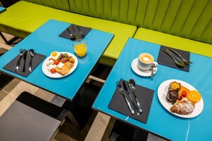 A dining area with blue tables and green seating.