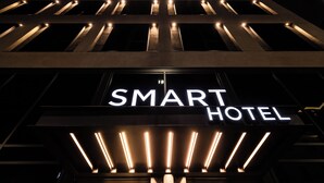 Een modern gebouw met een bord waarop 'SMART HOTEL' staat.