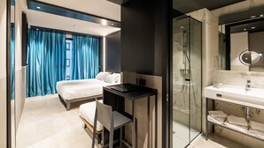 A modern hotel room with a bed, a desk, a shower, and a bathroom with a mirror and sink. - Smart Hotel Milano (Milan)