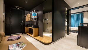 A modern hotel room with a wooden console table, a magazine, and a TV on a stand. - Smart Hotel Milano (Milan)