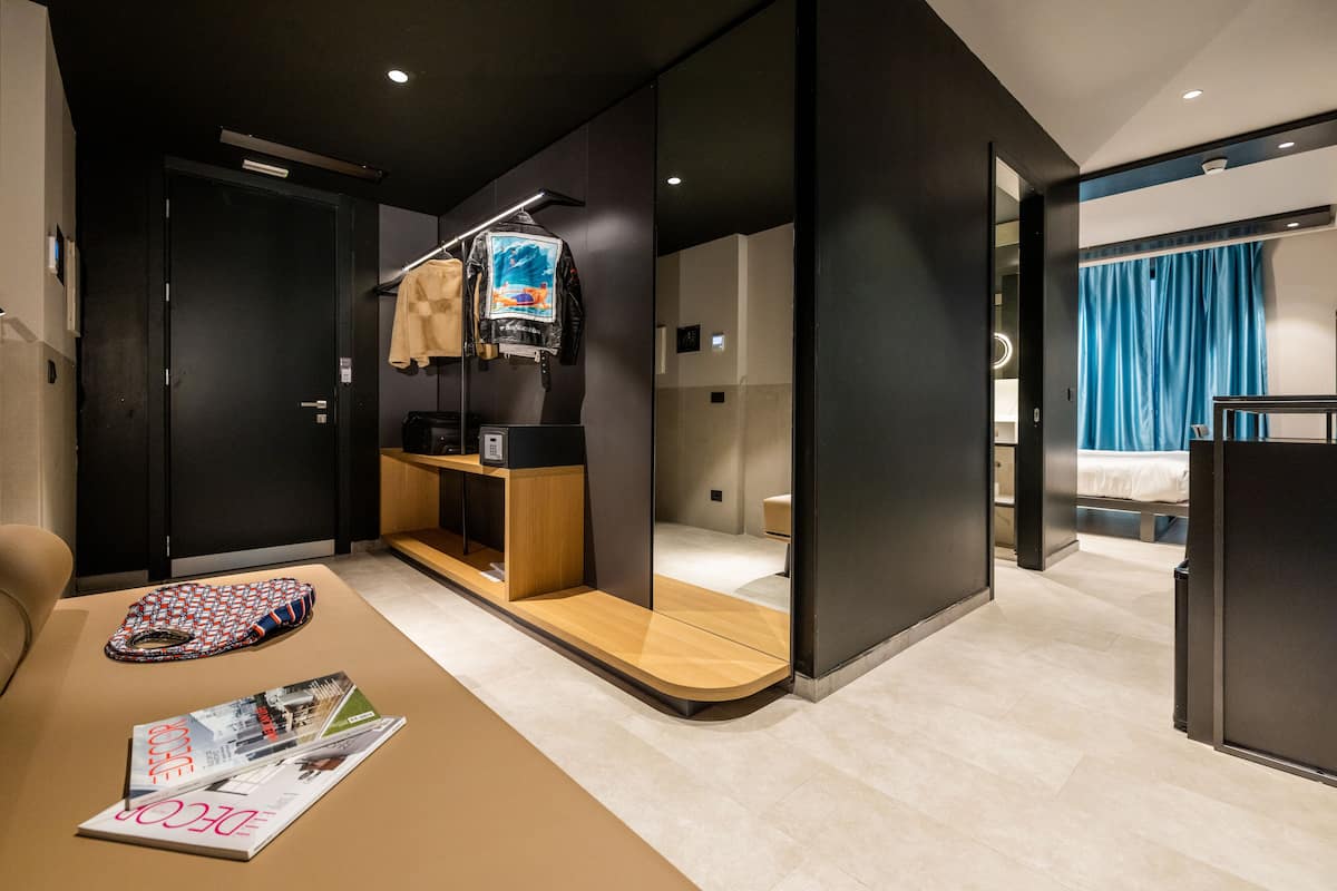 A modern hotel room with a wooden console table, a magazine, and a TV on a stand.