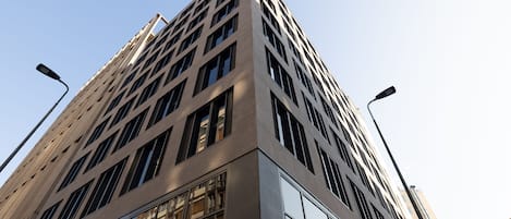 A tall, modern building with a grid-like facade and large windows.