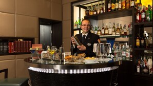 A bar area with a bartender, a variety of liquor bottles, and a well-stocked bar counter. - Mascagni Hotel (Rome)