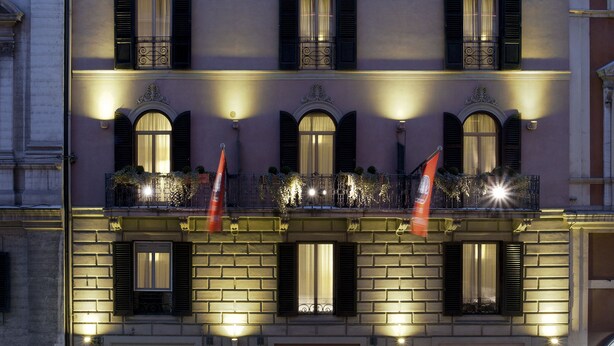 A multi-story hotel with a classic facade, multiple balconies, and a well-lit entrance. - Mascagni Hotel (Rome)