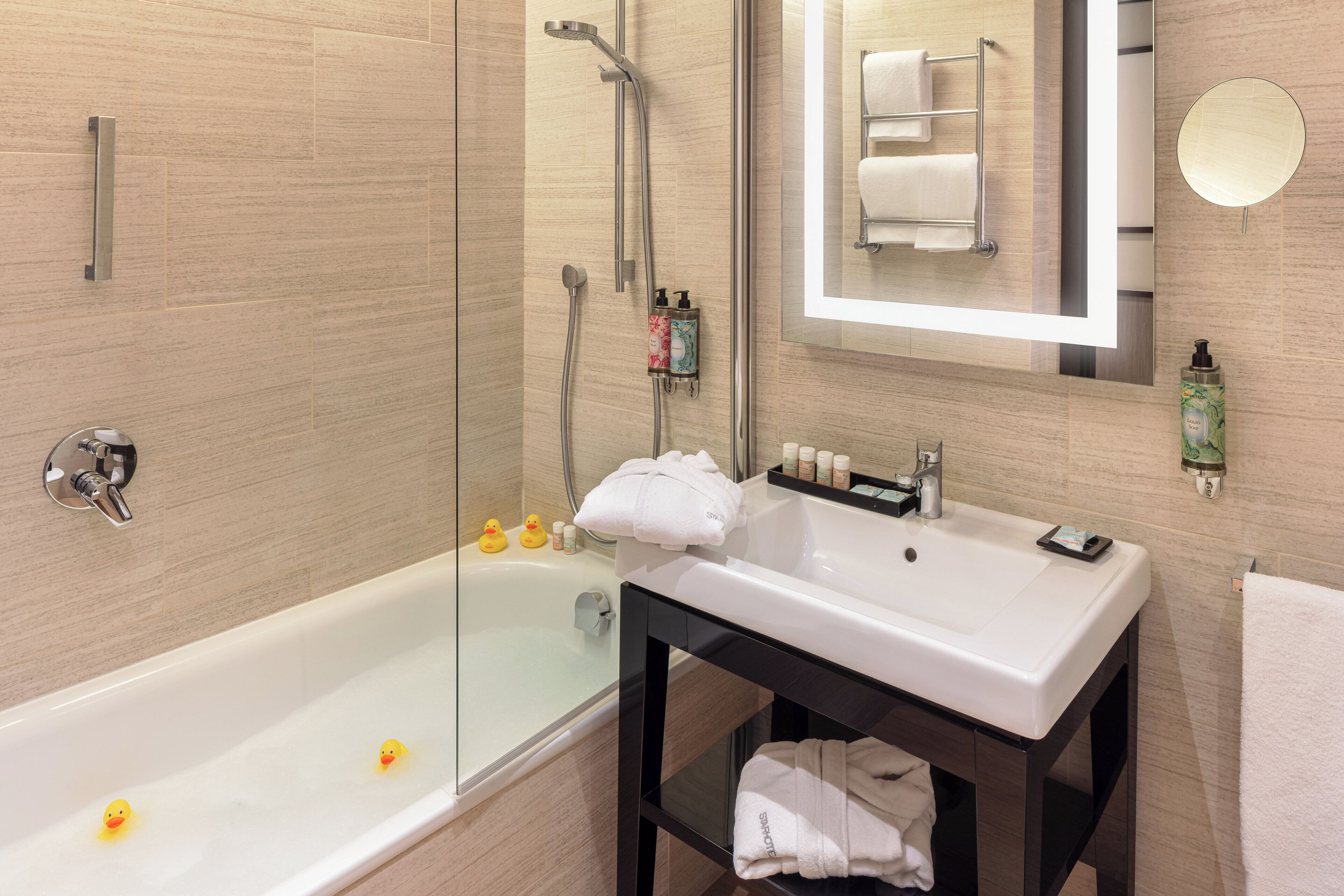 A modern bathroom with a bathtub, a shower, a sink, and a mirror.