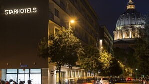 A StarHotels building with a large dome in the background. - Starhotels Michelangelo (Rome)