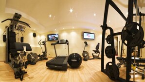 A gym with cardio machines, weightlifting equipment, and a treadmill. - Hotel Panama Garden (Rome)