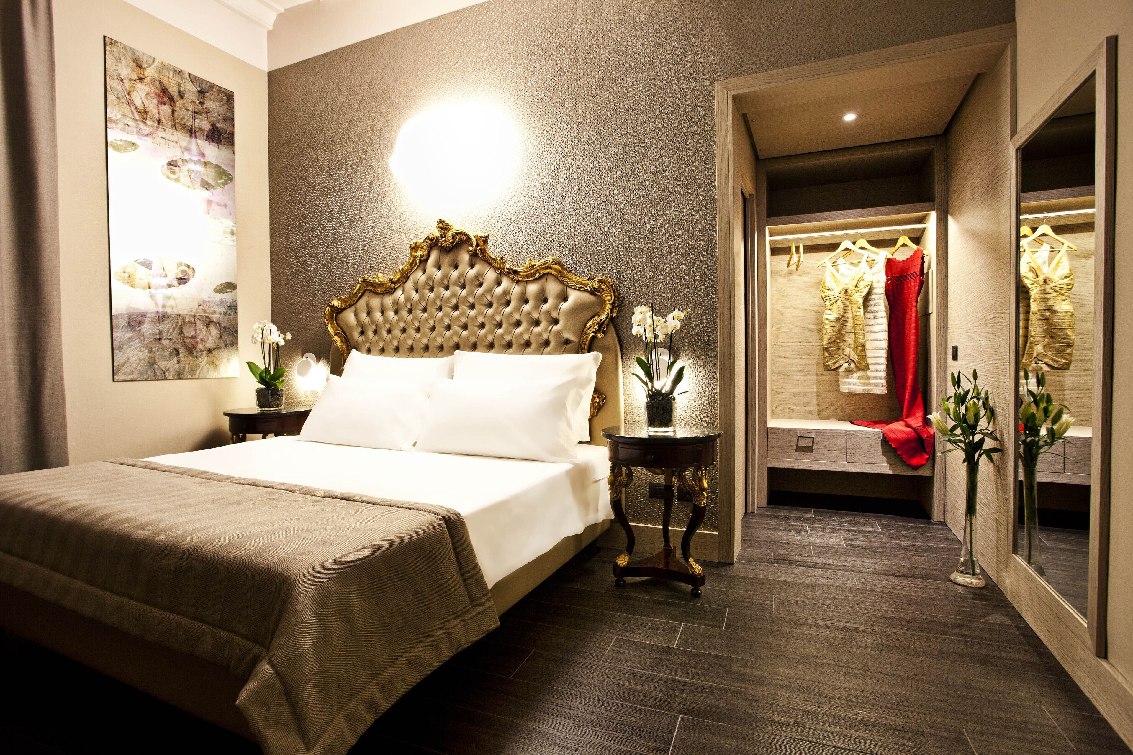 Une chambre à coucher avec un grand lit, une table de chevet, un miroir et une armoire.