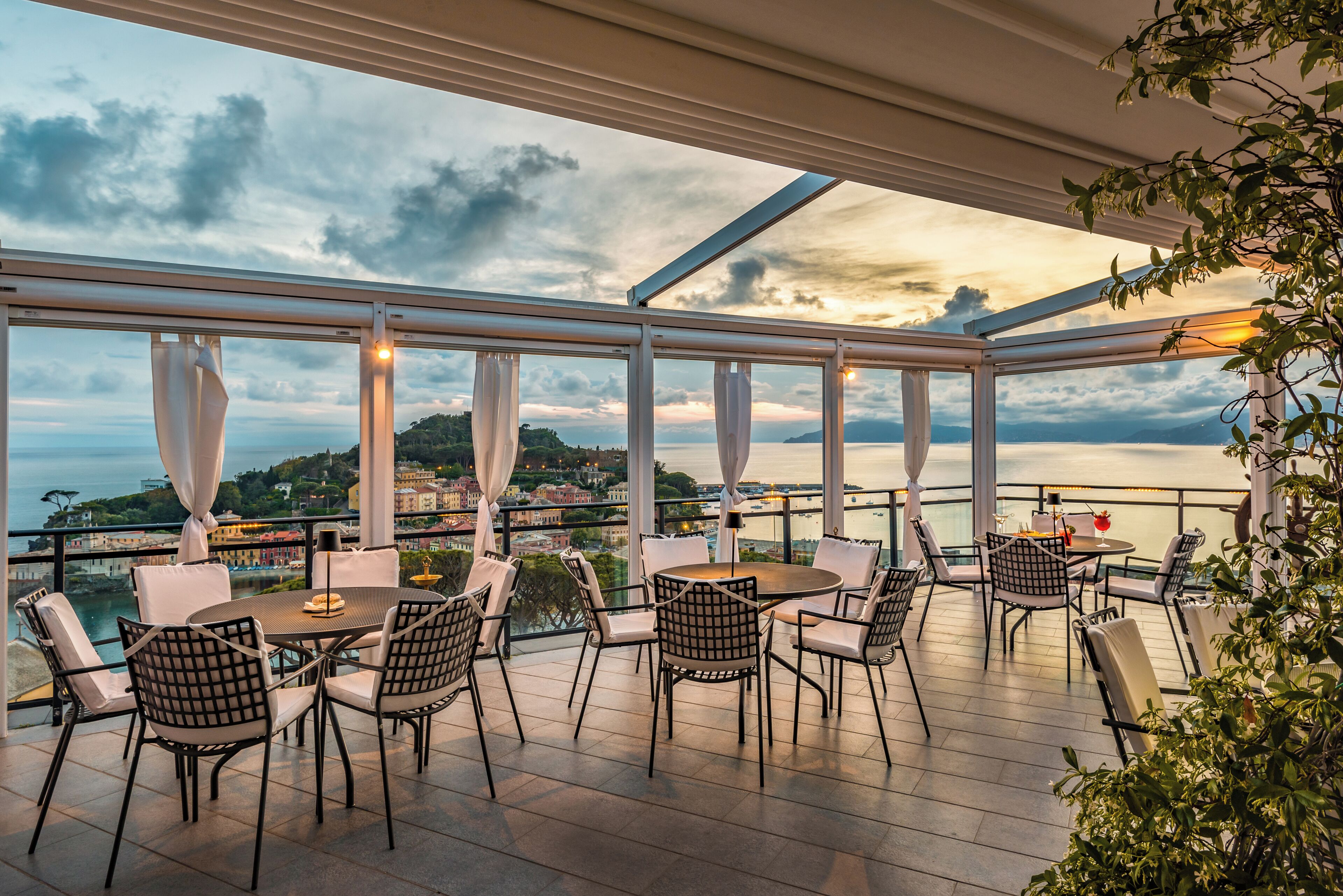 Una terraza con mesa y sillas, con vistas a un paisaje pintoresco de una masa de agua y tierra distante.
