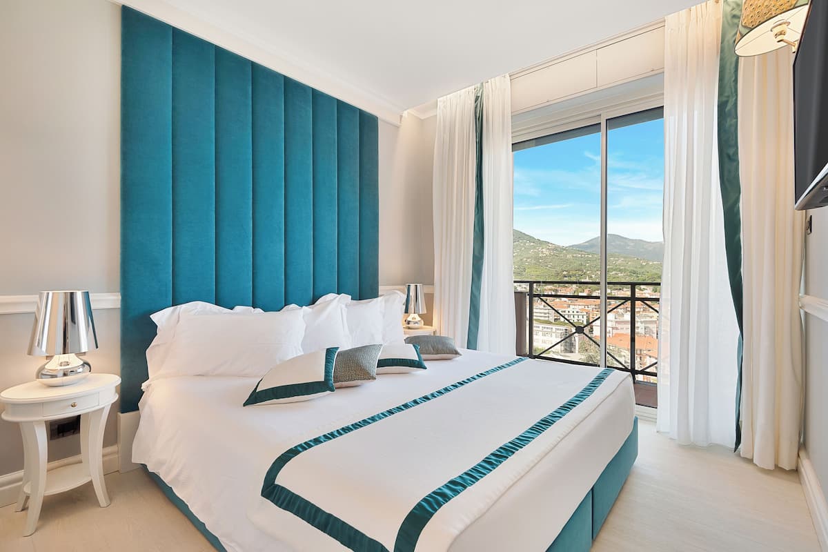 Suite junior, balcón, vista a la ciudad | 1 habitación, edredón, minibar y caja de seguridad en la habitación