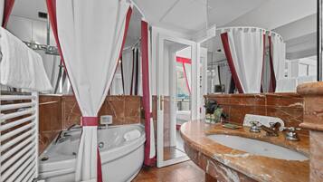 A bathroom with a bathtub, a sink, and a shower curtain.