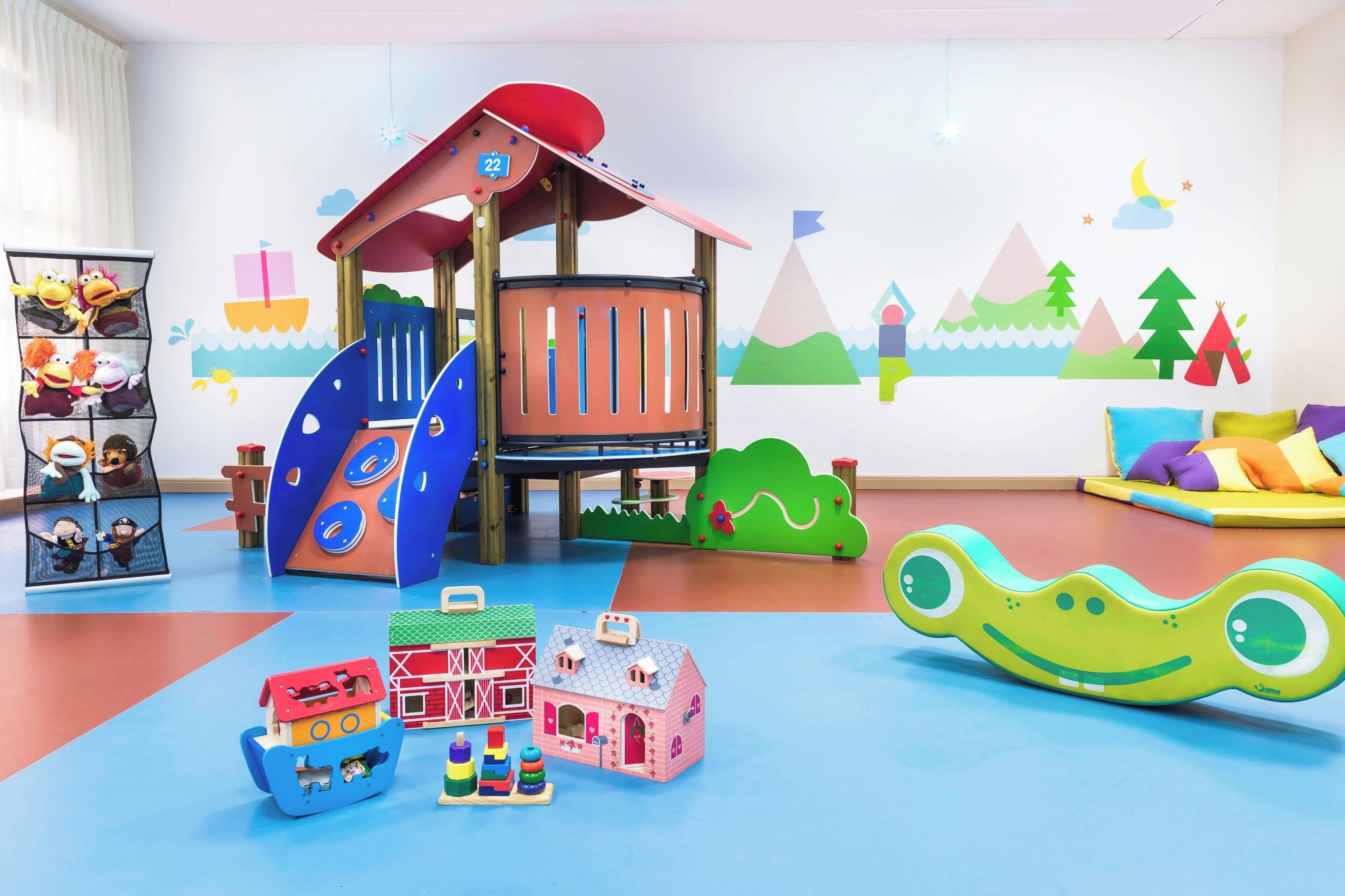 A children's play area with a slide, climbing structure, and various toys.