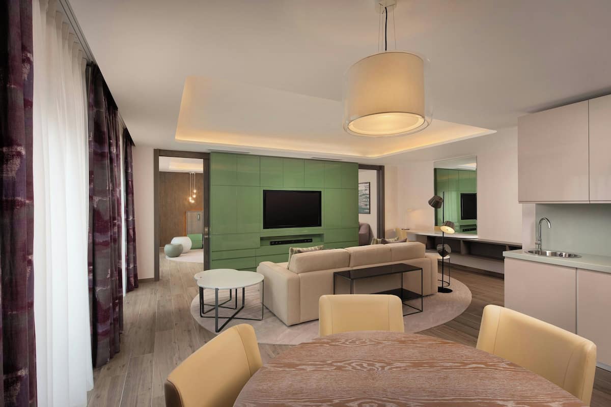 A modern living room with a sofa, a dining table, and a TV.