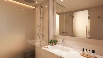 Un baño moderno con cabina de ducha de vidrio, un lavabo blanco y un espejo grande.