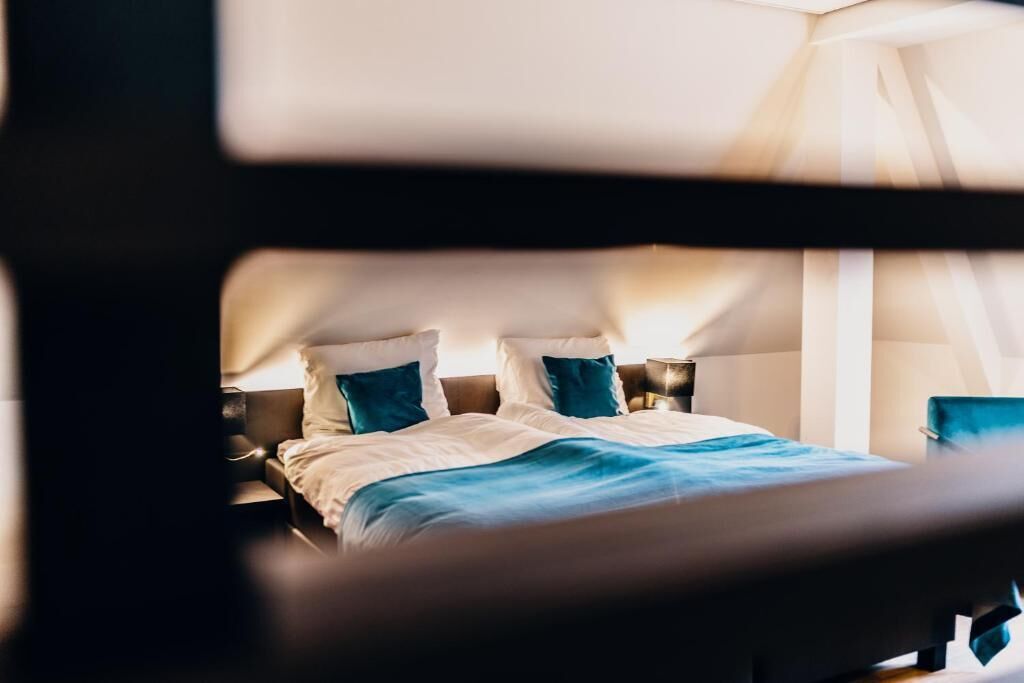 Ein Hotelzimmer mit Bett, Kissen und Nachttisch.