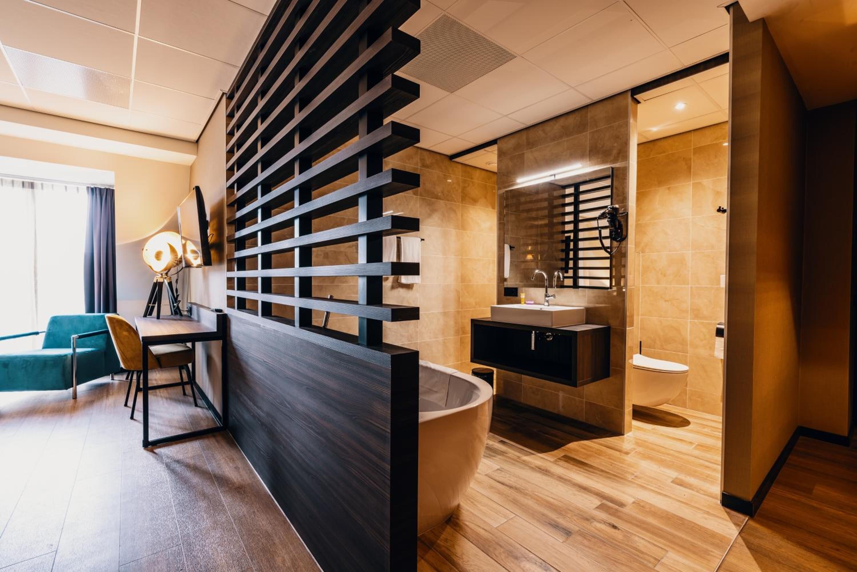 Une salle de bain moderne avec une baignoire sur pieds, un grand miroir et un lavabo contemporain.
