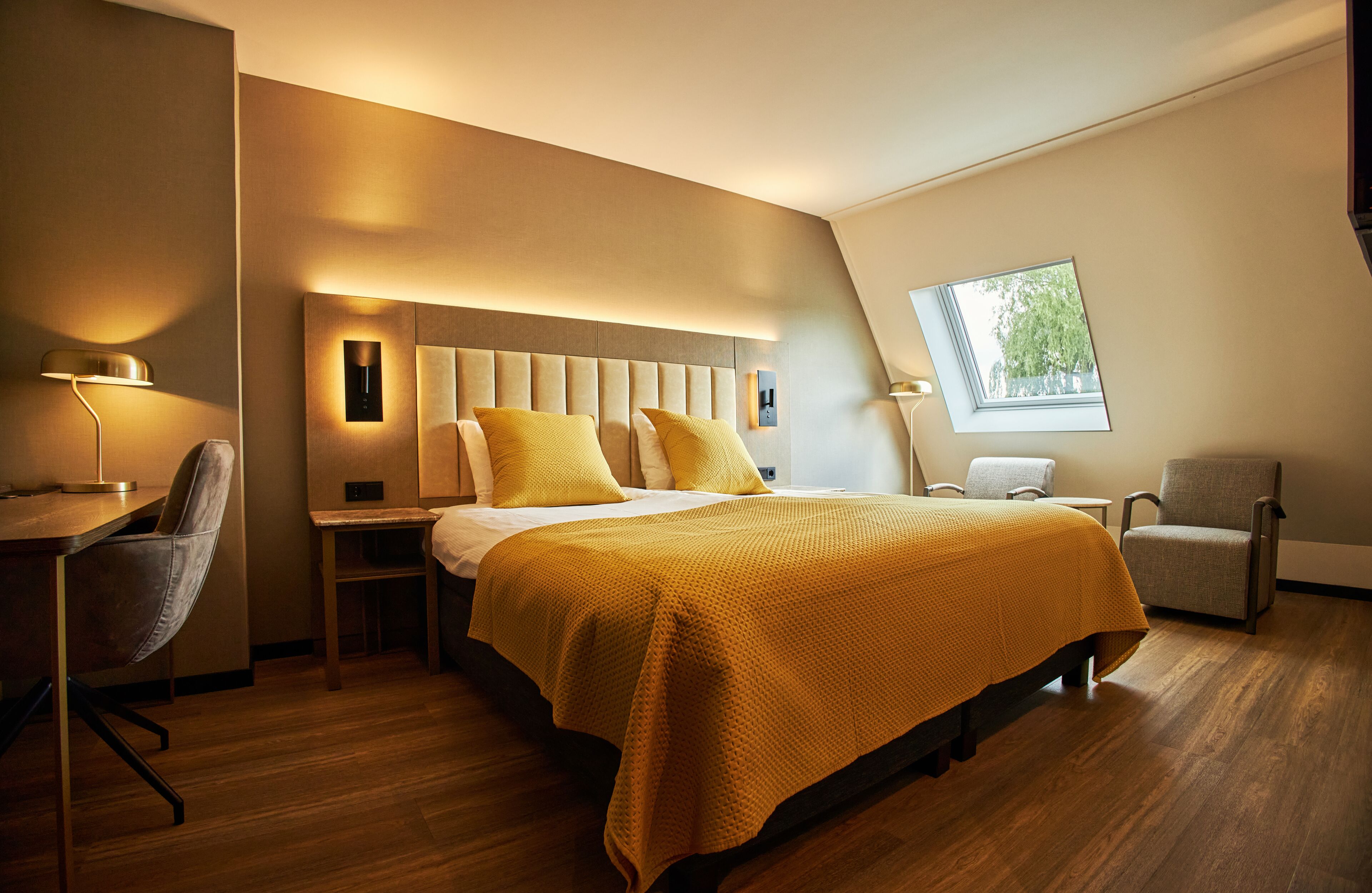 Una camera d'albergo moderna con un letto grande, una scrivania e una sedia.