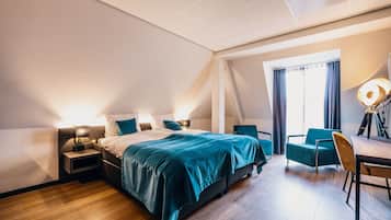 A modern hotel room with a large bed, a desk, and a chair.