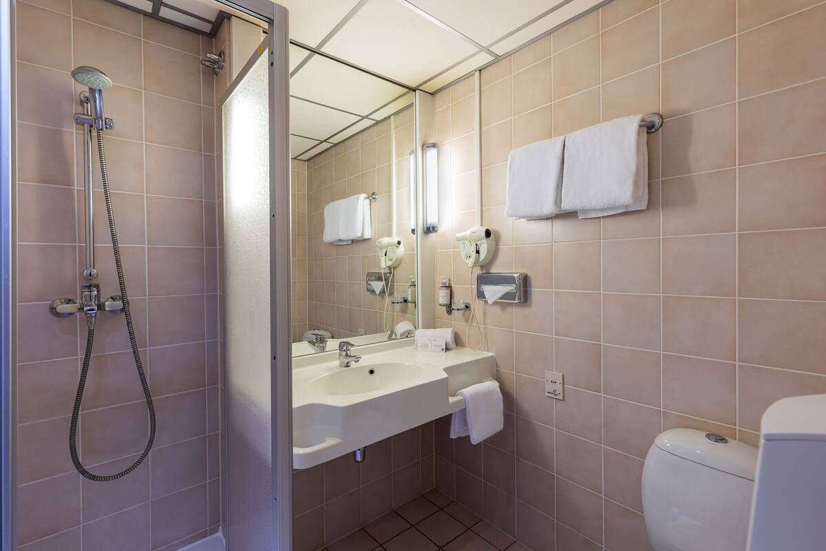 A bathroom with a shower, sink, and toilet.
