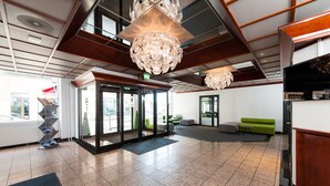 A lobby with a reception desk, a green sofa, and a large chandelier. - Thon Hotel Victoria Hamar (Hamar)