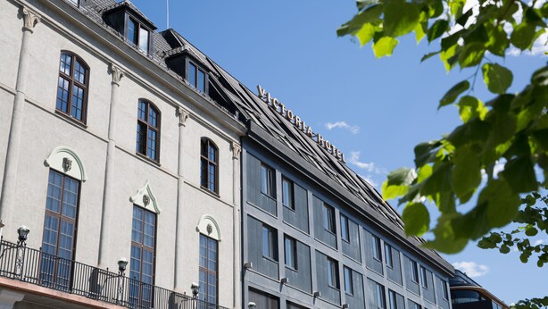 A building with a sign reading "VICTORIA HOTEL" on the roof.