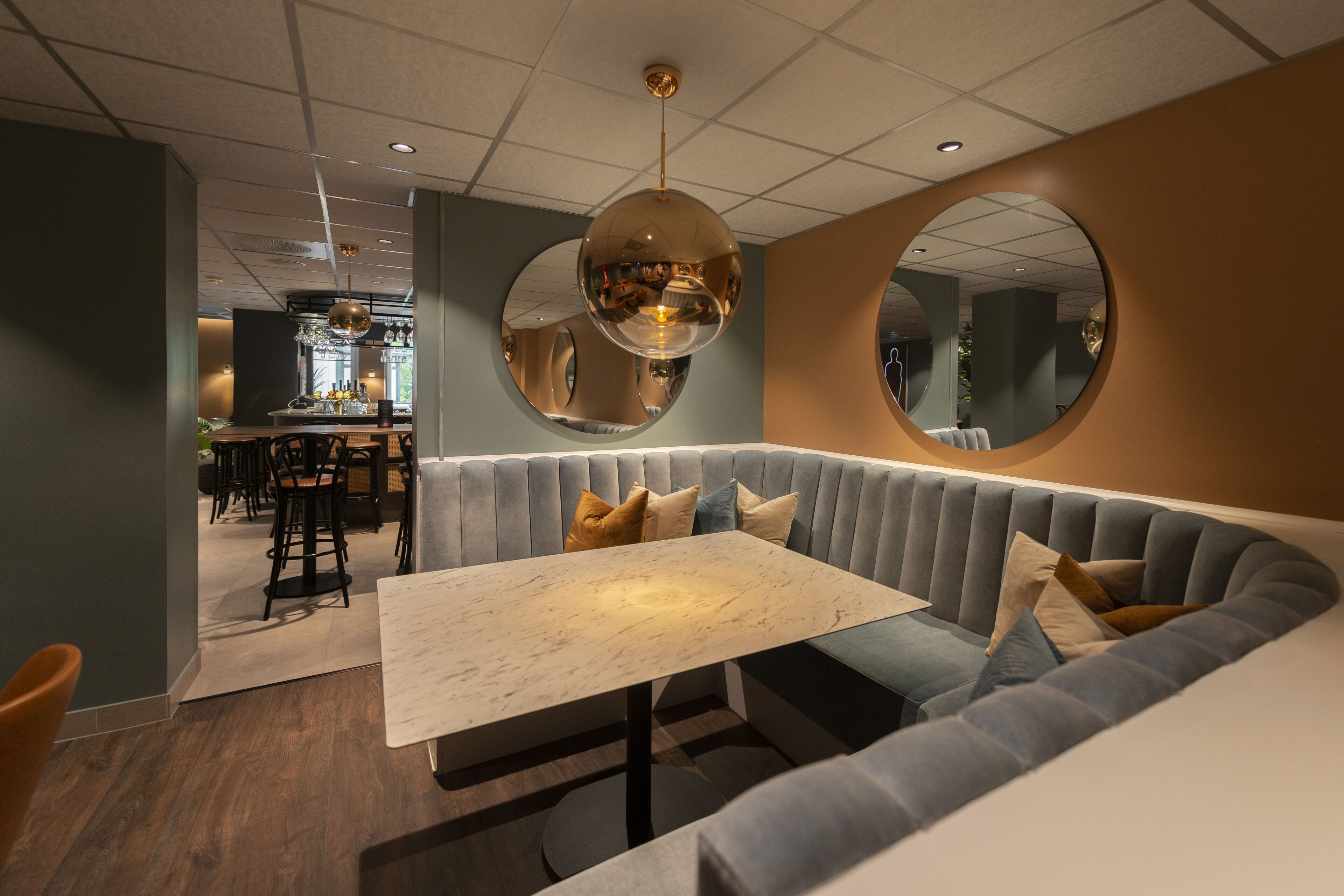 Ein modernes Interieur mit einer Sitzecke, die einen Marmortisch und gepolsterte Bänke bietet.