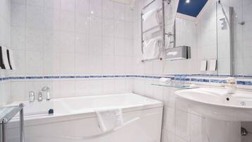 Un baño moderno con bañera, cabina de ducha de vidrio y lavabo con espejo.