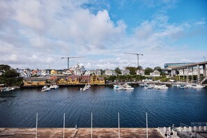 Un puerto con barcos amarrados, un muelle de madera y edificios al fondo.