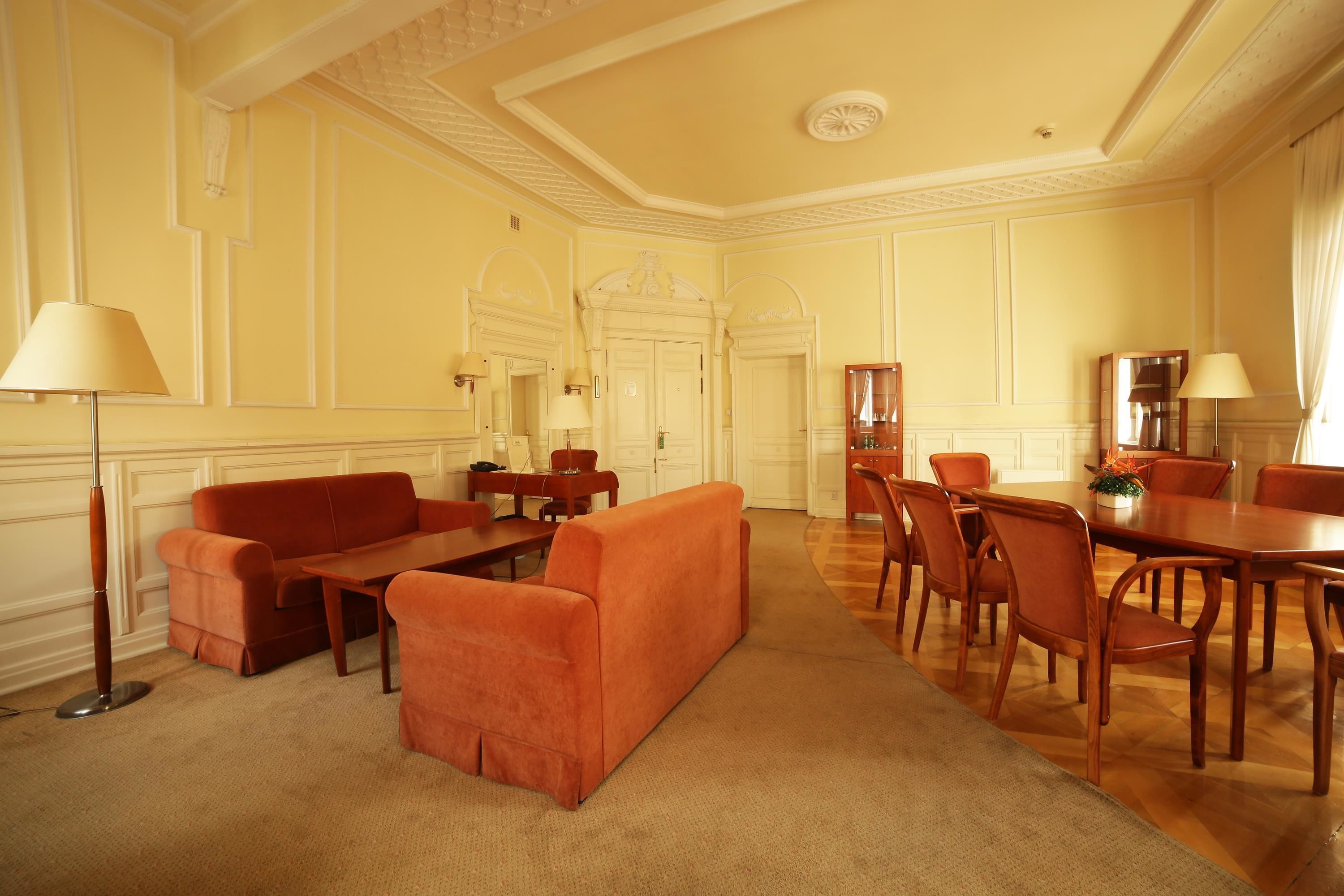 Un salon spacieux comprenant un canapé, une table basse et un coin repas avec des chaises.