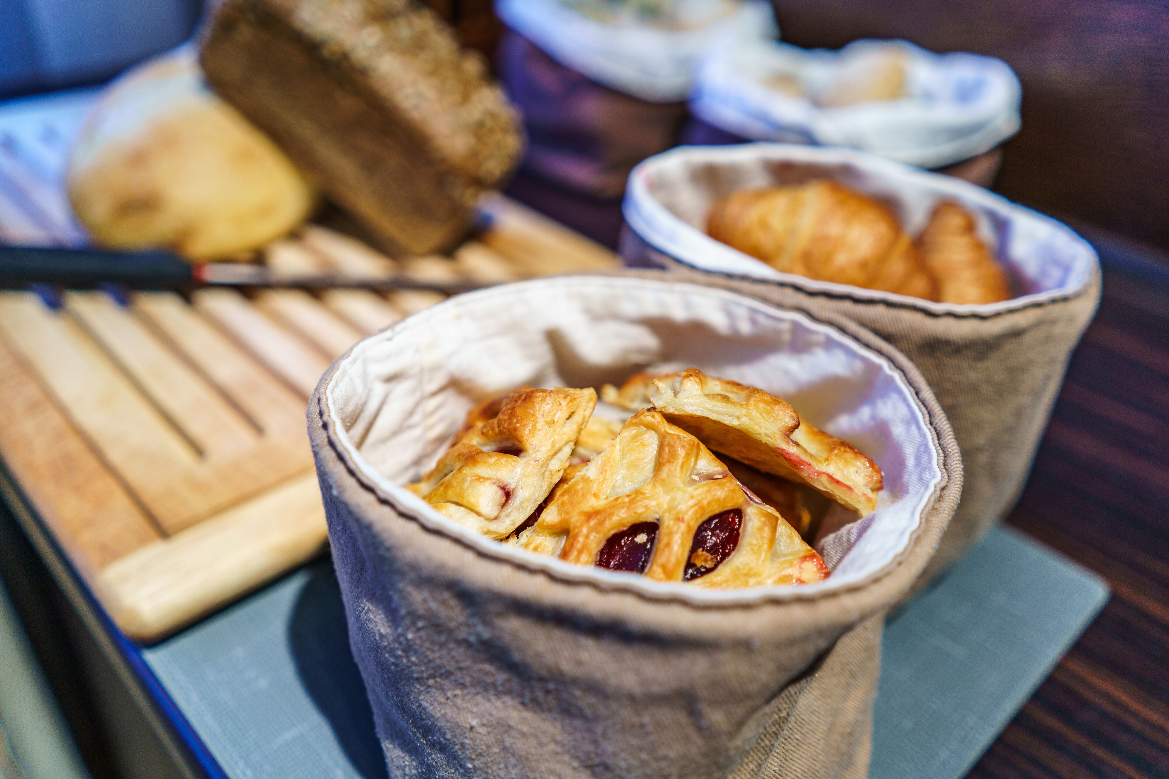 A wooden table with two fabric cups containing pastries.