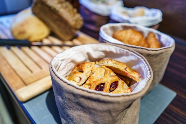 A wooden table with two fabric cups containing pastries.