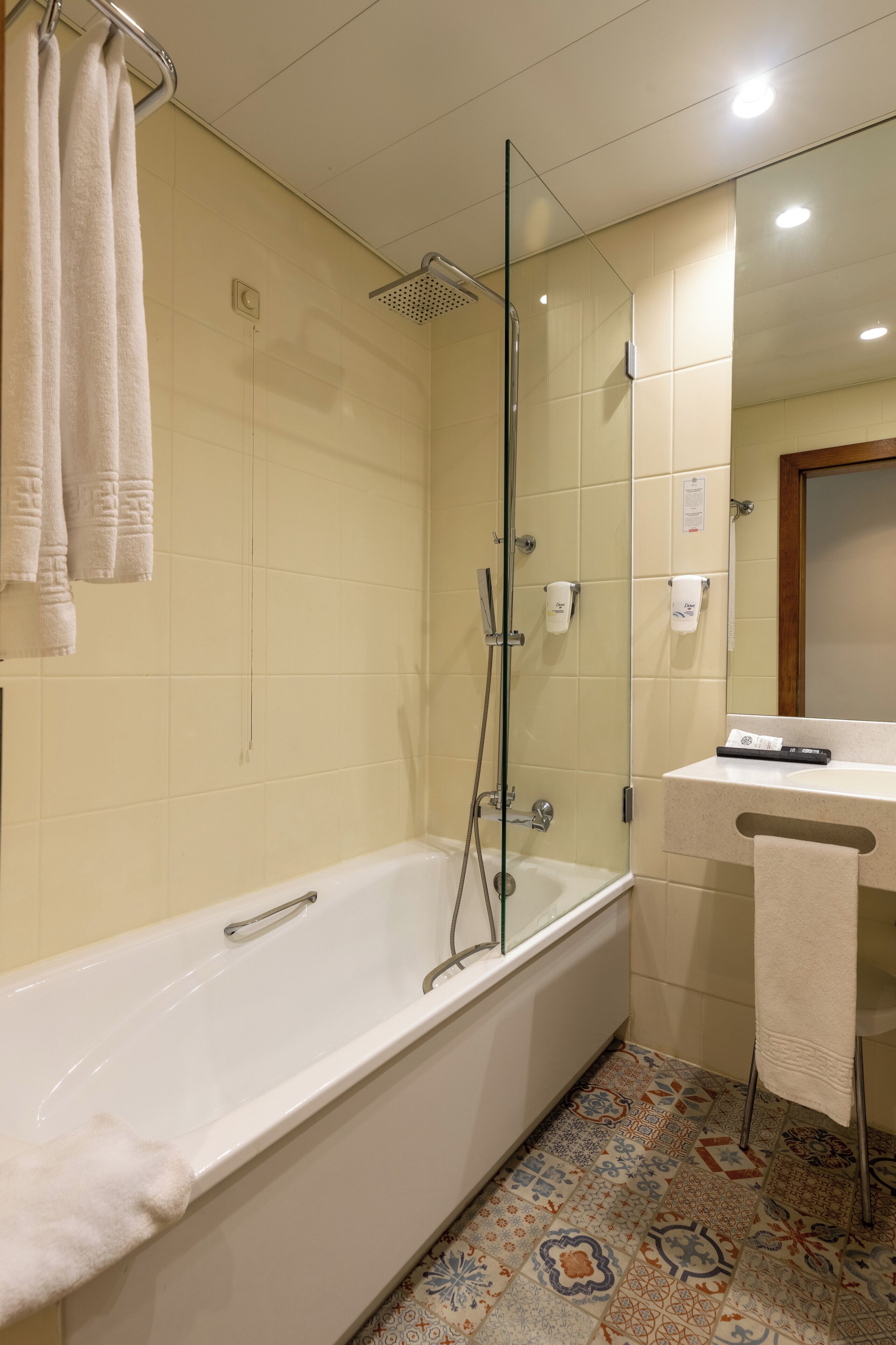 Un baño con bañera, ducha y lavabo con espejo.