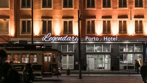 A building with a sign reading "Legendary Porto Hotel" and a tram in front. - Legendary Porto Hotel (Porto)