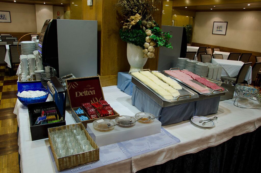 A buffet setup with various food items, a coffee machine, and a decorative vase.